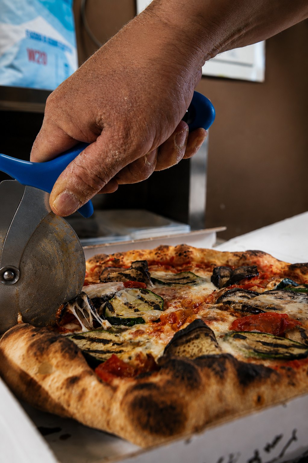 Il taglio di una pizza con verdure grigliate